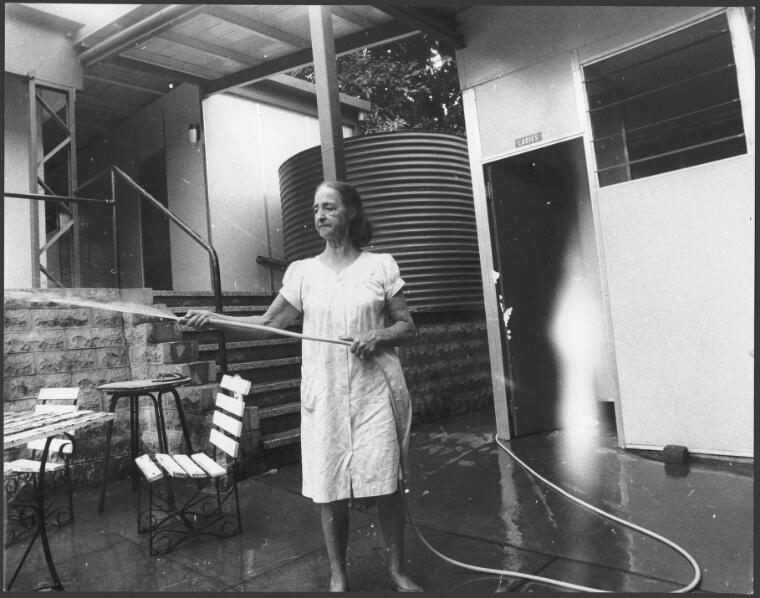A woman hoses down the beer garden on a Sunday morning at the Royal Hotel, Thursday Island, 1969