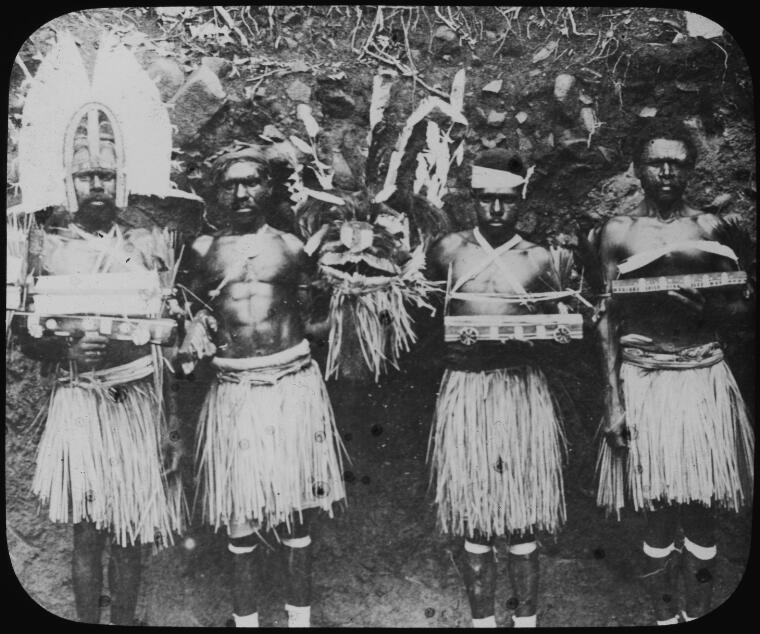 Four men in traditional dress and holding ceremonial objects, Hammond Island, Queensland, approximately 1905