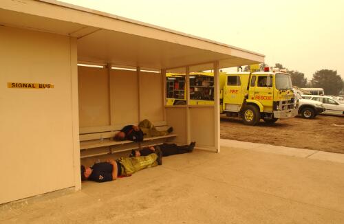 [Fire fighters having a rest at a bus stop in Duffy, Canberra bushfires, 18 January to 14 February 2003] [picture] / Damian McDonald