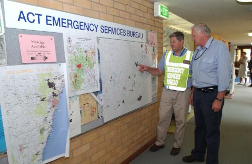 [Two officers looking at maps provided by ACT Emergency Services Bureau in Curtin, Canberra, January 2003] [picture] / Damian McDonald