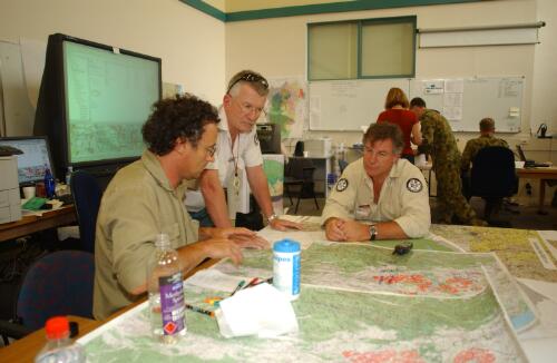 [Three officers looking at maps, Curtin, Canberra, January 2003] [picture] / Damian McDonald