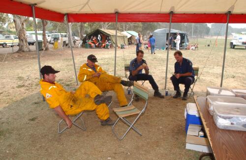 Fire fighters and officers taking a rest break under a shelter at Curtin, Canberra, January 2003 [picture] / Damian McDonald