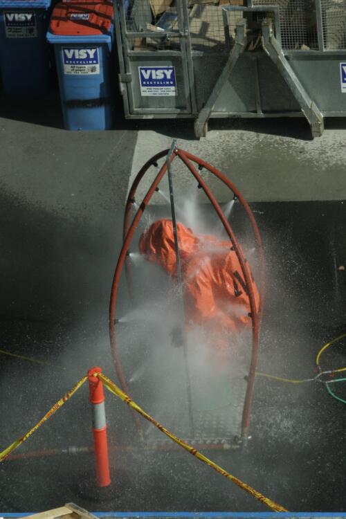 [A fire fighter is taking a decontamination shower in the loading bay at the National Library of Australia in response to the delivery of suspicious mail, 6 May 2005, 3] [picture] / Greg Power