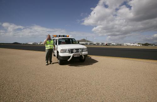 Warren Jones, Safety Office, communicates from the runway by mobile telephone, Townsville International Airport, Townsville, Queensland, 30 May 2005 [picture] / Loui Seselja