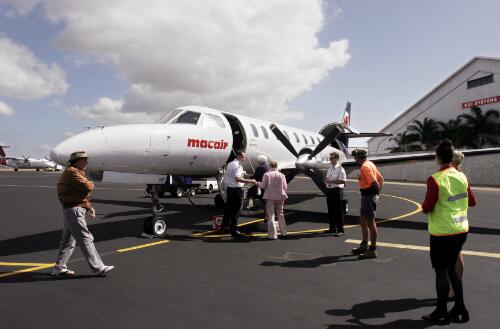 Captain Richard Godden and First Officer Troy Clegg assist passengers to board MacAir Airlines' Fairchild Metro VH-UUF to Longreach via Winton, Townsville International Airport, Townsville, Queensland, 31 May 2005 [picture] / Loui Seselja