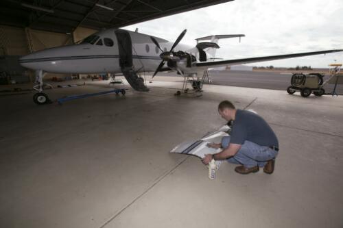 First Officer Rodney Carter polishes the engine cowlings of Air Link Airlines' Beechcraft 1900 D, VH-RUE during routine maintenance work at the Air Link Hangar, Dubbo Airport, New South Wales, 9 June 2005 [picture] / Loui Seselja