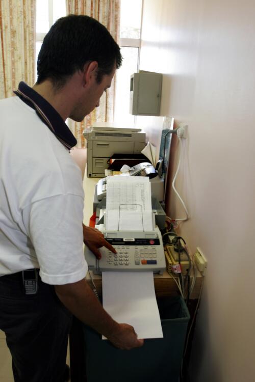 Doctor Charles Ellis, Royal Flying Doctor Service of Australia, sends a patient's medical records by fax to Cairns Base Hospital, Croydon Hospital, Croydon, Queensland, 17 June 2005 [picture] / Loui Seselja