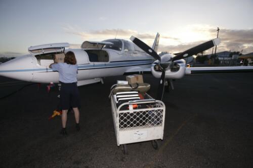 Flight Nurse Gayle Rusher loads medical equipment onto a Cessna 404, VH-TFO, operated by Hinterland Aviation for the Royal Flying Doctor Service of Australia's clinic flights to Einasleigh, Georgetown and Croydon, Cairns Airport, Cairns, Queensland, 16 June 2005 [1] [picture] / Loui Seselja
