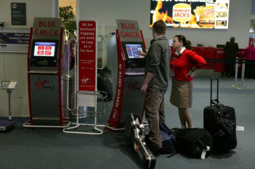 A Virgin Blue check-in employee assisting a passenger in the use of Virgin Blue's self service check-in "Blue Check", Tullamarine Airport, Melbourne, 21 June 2005 [picture] / Damian McDonald