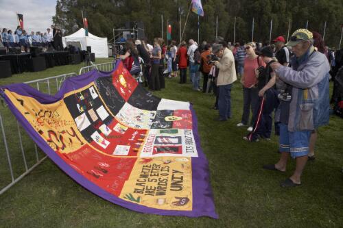People looking at and photographing a banner displayed for the Apology to the Stolen Generations of Australia, Canberra, 13 February 2008 [picture] / Damian McDonald