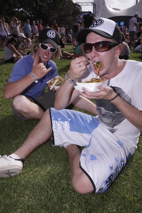 Music fans Mozzie and Mike sitting on the grass eating takeaway food, The Domain, Sydney, 6 December 2008 [picture] / Greg Power