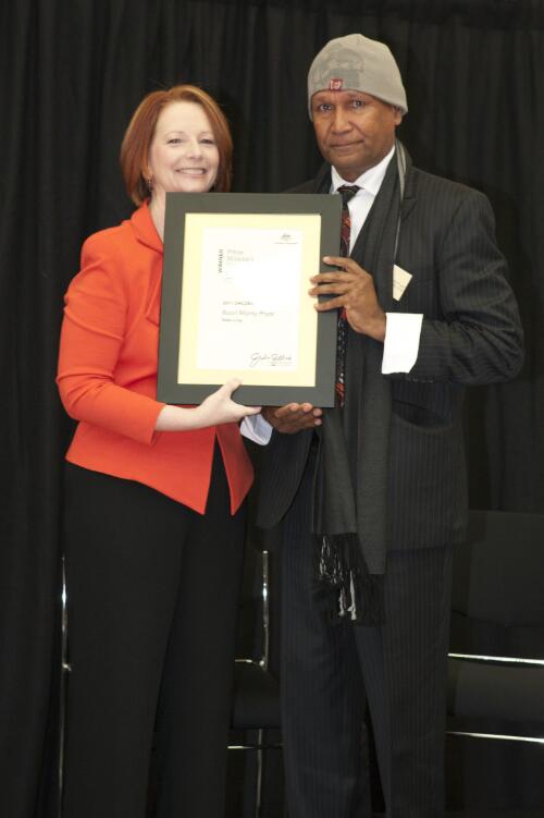 Prime Minister Julia Gillard presenting Boori Monty Pryor with his award for winning the children's fiction category at the Prime Minister's Literary Awards held at the National Library of Australia, Canberra, 8 July 2011 [picture] / Sam Cooper