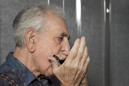 Les Bruton playing the harmonica during a recording session at the National Library of Australia, Canberra, 2012 [picture] / Craig MacKenzie
