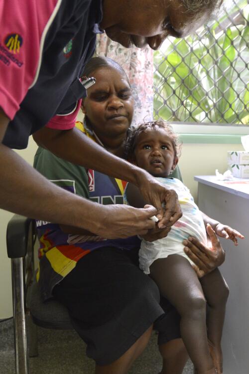 Alice Tayley takes a blood sample from Keithean Nunn held by her mother, Cyndall Yougie, at Wujal Wujal Primary Health Care Centre, Wujal Wujal, Queensland, October 2014 / Darren Clark