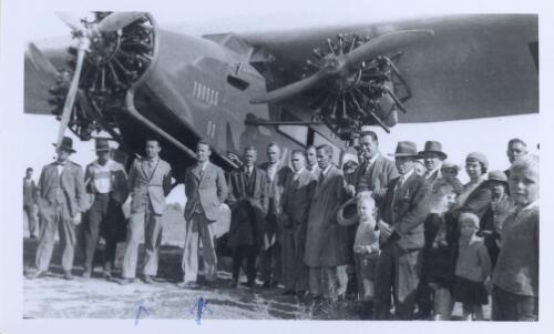 Group of people, including Charles Kingsford Smith and Pat Hall, standing in front of the Southern Cross [picture]