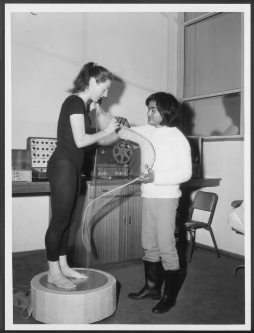 Young Australian choreographer Philippa Cullen standing on a pedestal aerial examining a bonnet aerial with architecture student Manuel Nobleza, 1972 [picture] / Australian Information Service photograph by Alex Ozolins