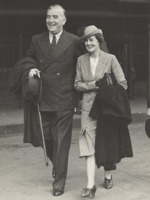 [Pattie and Sir Robert Menzies walking along a street] [picture] / Photograph from the Age