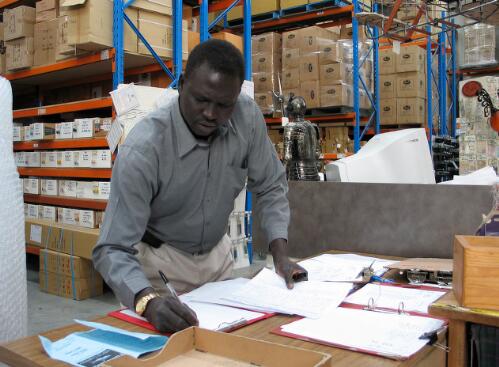 Hakim Mabior, in his job as storeman at Boyle Pty Ltd, prepares to assemble goods for packaging and delivery, Melbourne, 2005 [picture] / June Orford