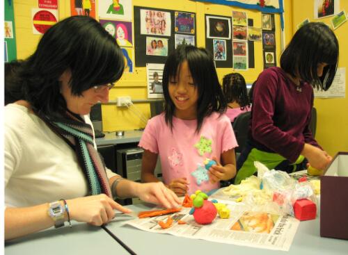 Program co-ordinator, Kerry Finlayson, helps Luci Nguyen with her clay modelling at the Fitzroy Learning Network, Fitzroy, Victoria, 2005 [picture] / June Orford
