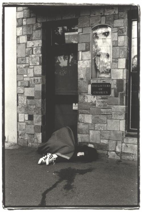 A homeless person sleeping in the entrance to St Mary's House of Welcome run by Daughters of Charity, Brunswick Street, Fitzroy, Victoria, 2000 [picture] / Darren Clark