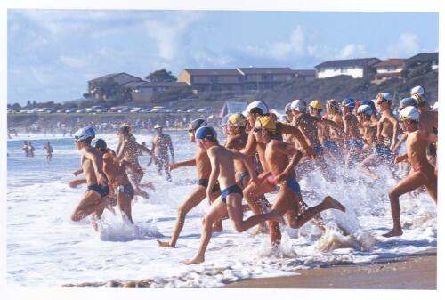 Nippers running into the surf at a mid-north coast beach, New South Wales, 1990 [picture] / Jeff Carter