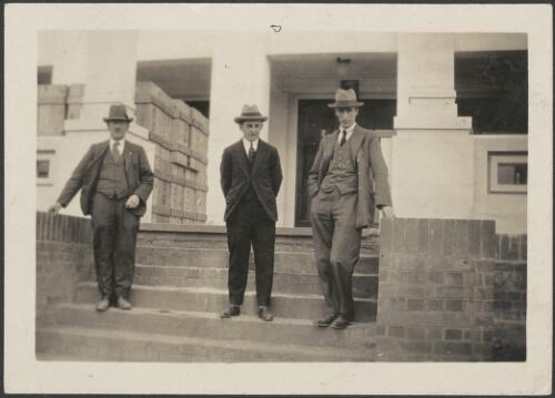 Officers and book cases on the steps of Parliament House during removal, from left, G. Millard, H.L. White and J. Whittle, 1926 [picture] / K. Binns