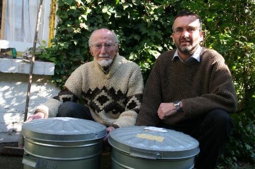 Dr Phillip Law and Gavan McCarthy sitting in front of two steel bins filled with Dr Law's diaries and notebooks, 2006 [picture] / Helen Morgan