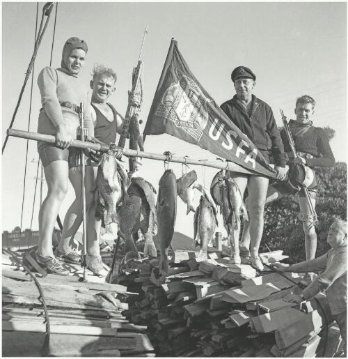 Lois Linklater, Bill Heffernan, Dick Charles and Don Linklater with Underwater Spear Fishermens Association flag at Hawks Nest, New South Wales, ca. 1950 [picture] / Jeff Carter
