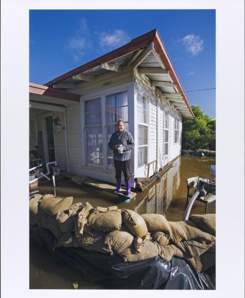 A local resident standing in front of her flooded house, Paynesville, Victoria, 2007 [picture] / Rodney Dekker