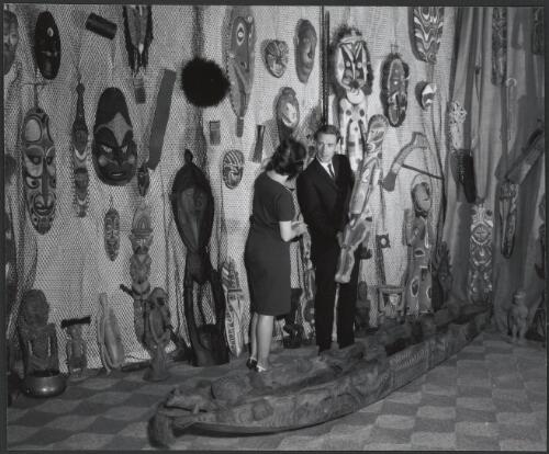 Mr Robert Ypes of the Native Arts Gallery, displaying a sacred haus tambaran figure and a ceremonial canoe from the Sepik district of New Guinea, Sydney, New South Wales, 1966 [picture] / A. Ozolins