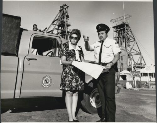 Sergeant Keith Ford helps Constable Dube get to know Broken Hill with a map on one of the city's high spots near the shafts of the Broken Hill South mining company 1973 [picture]