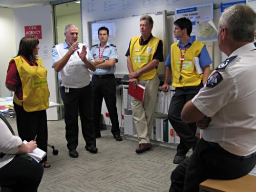 Neil Bumpstead, Country Fire Authority operations manager, briefing team leaders at the Integrated Emergency Coordination Centre regarding bushfires in Victoria, 3 March 2009 [picture] / June Orford