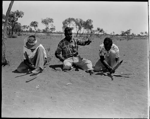 Three Aboriginal men handcrafting a boomerang, rope and shield at the Warrabri Settlement, Northern Territory, ca. 1958 [picture]
