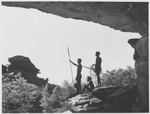 Four Aboriginal Australian males looking out from a rock at Obiri in Arnhem Land, Northern Territory, 1963 [picture]