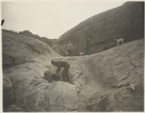 Captain S.A. White's party baling water for camels from a rock hole in the Everard Ranges, Central Australia, 1913 [picture] / Captain S.A. White