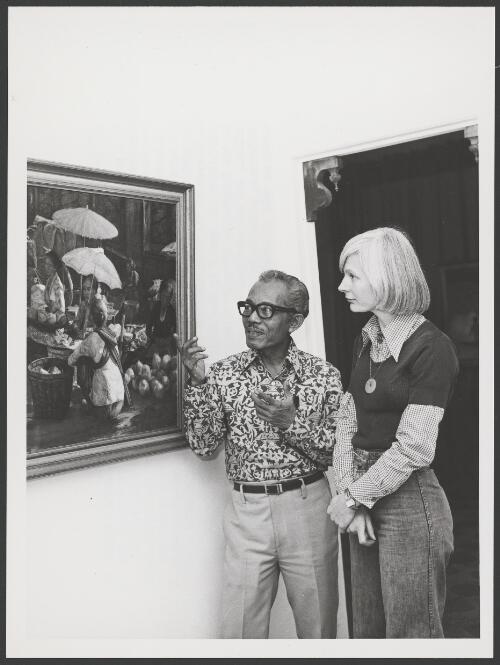 Dullah describes an Indonesian market scene to a gallery visitor, East and West Art Gallery, Melbourne, 1977 [picture] / Australian Information Service photograph by Norman Plant