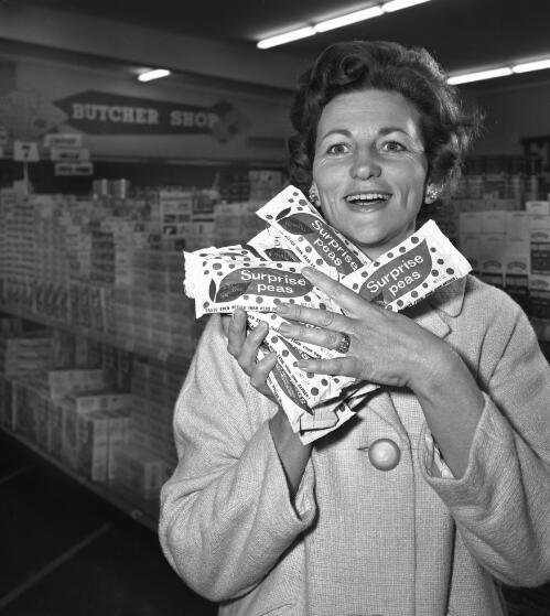 A woman shopper holding packets of surprise peas at Merrylands Shopping Centre, New South Wales, 17 July 1966 [picture] / Ern McQuillan