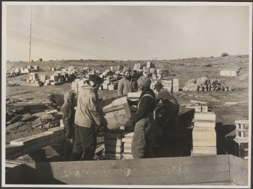 Expedition members unloading stores during the changeover, Antarctica,1955 [picture] / George Lowe