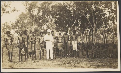 Group of Aboriginal men of the Yolngu language group standing with H.E. Boote next to a group of Aboriginal women sitting, Elcho Island, Northern Territory, ca. 1923 [picture]