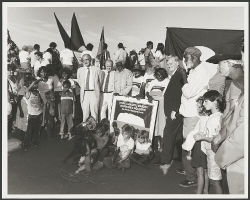 Sir Ninian Stephen, Clyde Holding, Mr Peter Bulla, Mr. Peter Kanari, Mr. Nipper Winmarti, Barbara Tjirkadu, Barry Cohen and Aboriginal men, women and children at the official ceremony of the handover of Uluru to its traditional owners, Northern Territory, 5 November 1985 [picture] / Department of Aboriginal Affairs