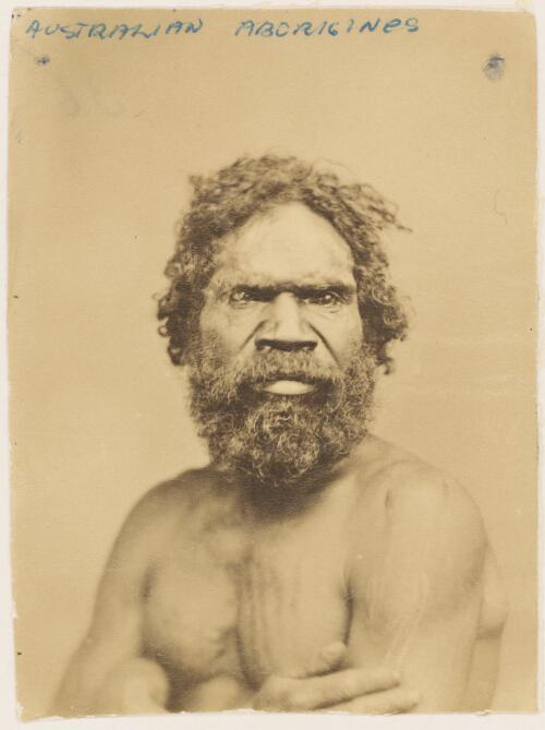 Portrait of a bearded Aboriginal man with his arms folded displaying his decorative scarring [picture]