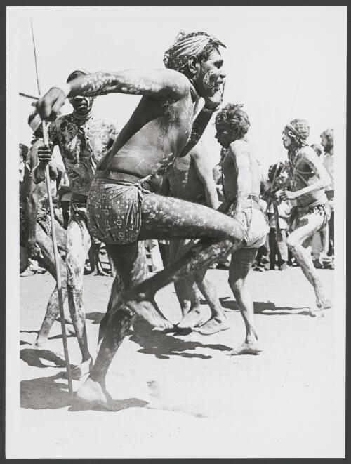 Aboriginal Gurindji men performing a ceremonial dance with spears during the official return of Aboriginal land at Wattie Creek, Daguragu, Northern Territory, 26 August 1975 [picture] / Penny Tweedie