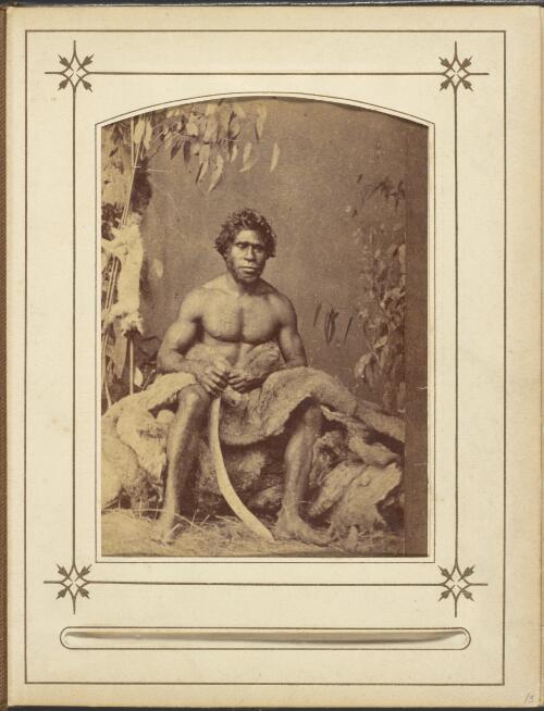 Studio portrait taken ca. 1866 of Victorian Aboriginal man, Freddy Wheeler sitting holding a boomerang, ca. 1890 [picture] / Thomas J. Washbourne