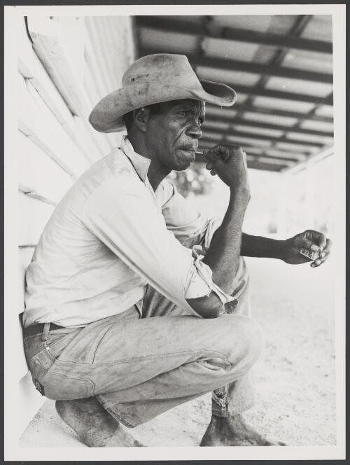 Aboriginal stockman leaning against a weatherboard house, Northern Territory, ca. 1975 [picture] / Bob Nicol