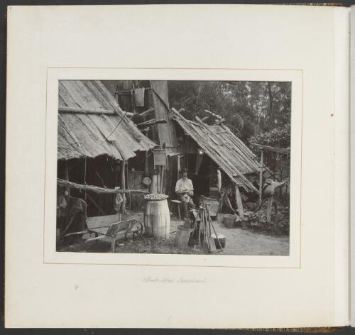 A man sitting outside a bush hut, Gippsland, Victoria, ca. 1900 [picture] / Nicholas Caire