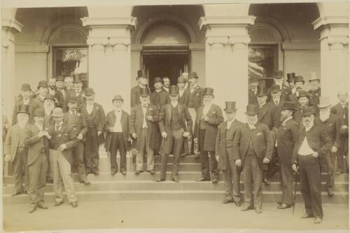 Lord Hopetoun,  Governor of Victoria, standing on the steps of Government House surrounded by a large group of politicians[?], Melbourne, Victoria [picture]