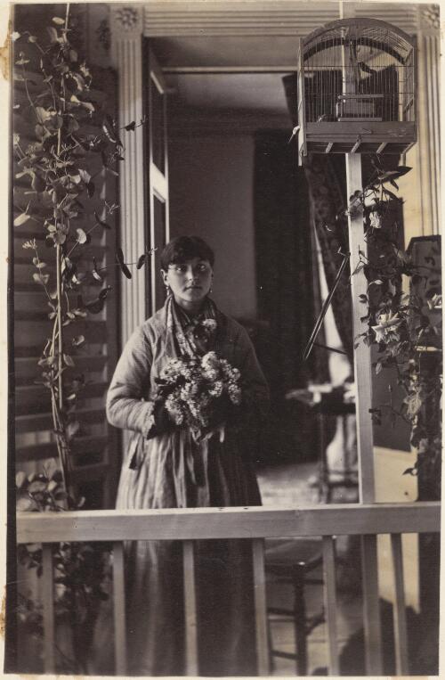 Young woman on a balcony, holding flowers, France? [picture] / J. Chester Jervis