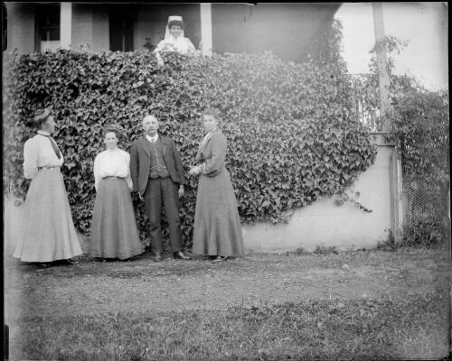 Four people in a garden, with a nurse on a verandah above them at the old hospital, Gundagai, New South Wales [picture] / Charles Gabriel