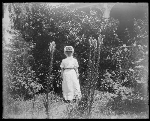 Mrs Cross standing in a garden, Gundagai, New South Wales, 1 [picture] / Charles Gabriel