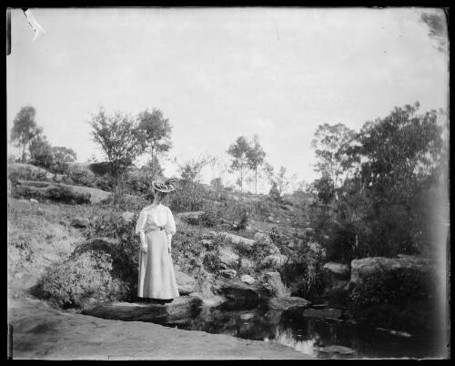 Dr. Gabriel's wife Jessie, standing near a small pool of water amongst the rocks, Gundagai, New South Wales [picture] / Charles Gabriel